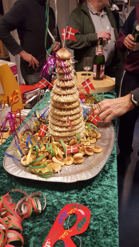 Der er en (Jens Ole) der er i gang med at tage noget af pynten omkring Heidis flytte kransekage. 